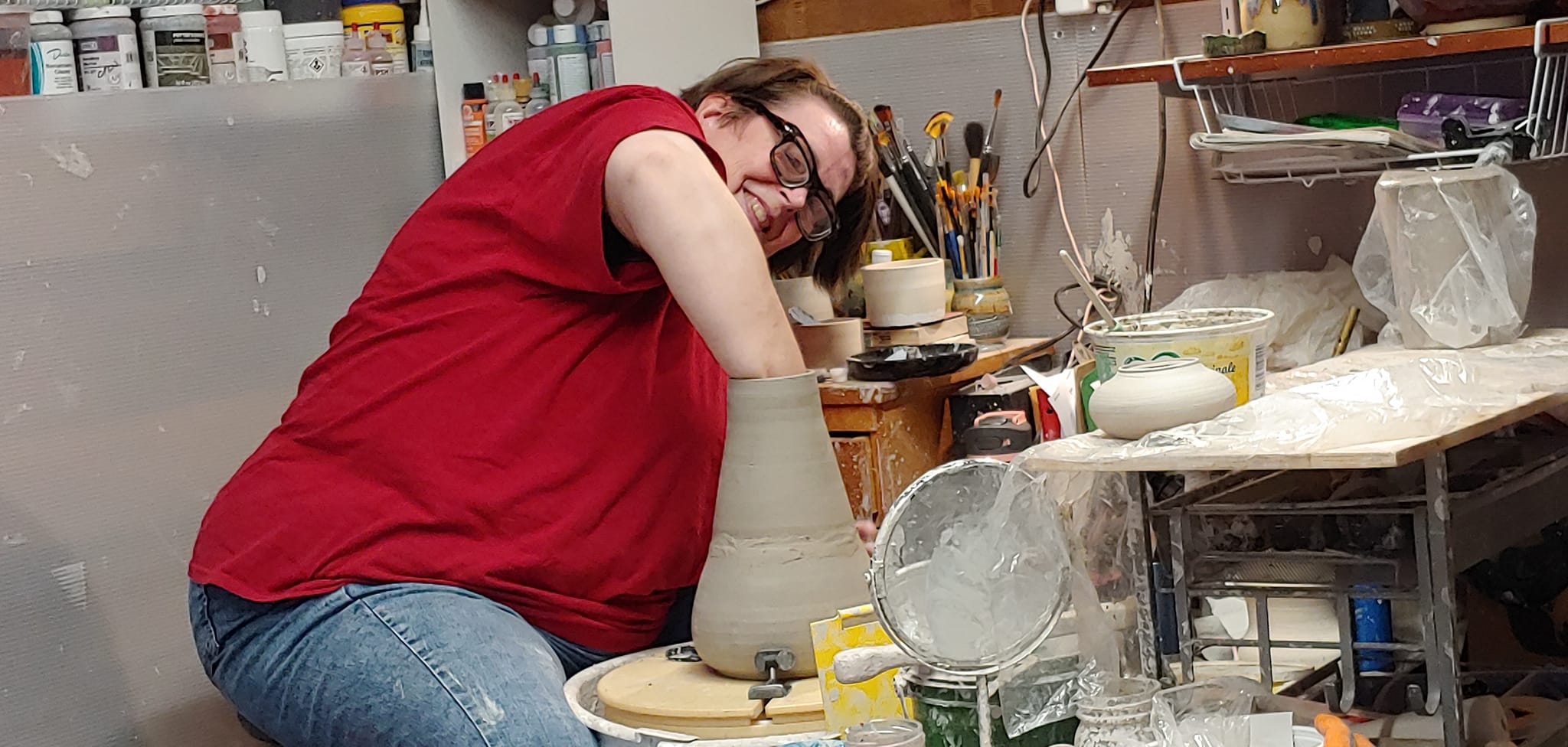 A student at work throwing on the wheel